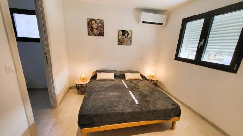 une chambre avec un lit et deux fenêtres dans l'établissement Villa Silvio, 8 pers, piscine, 15 minutes plage en voiture, à Sainte-Lucie de Porto-Vecchio