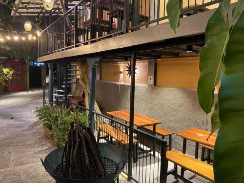 a restaurant with wooden tables and benches and a balcony at Settle Inn Tourist Lodge in Kandy