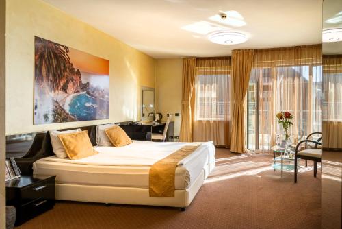 a hotel room with a large bed and a desk at Europe Hotel in Sofia