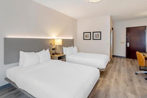 a hotel room with two beds and a desk at Comfort Inn & Suites Sayre in Sayre