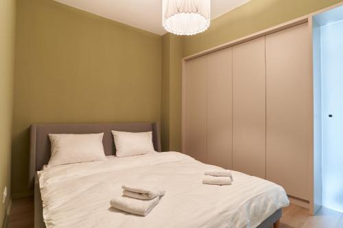 a bedroom with a large bed with towels on it at Alternativ 3 Residence Central in Timişoara