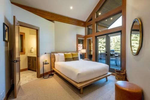 a bedroom with a bed and a large window at Glacier View Chalet - Tranquil Chalet with Private Hot Tub & Golf Course Views - Whistler Platinum in Whistler