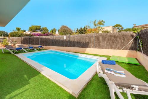 a swimming pool in a yard with chairs and a fence at Villa Cladera in Alcudia Playa de muro beach private pool in Alcudia