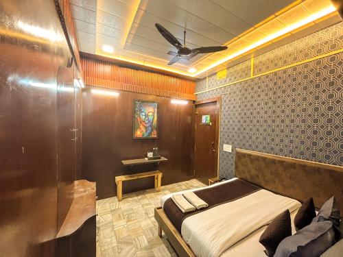 1 dormitorio con 1 cama y ventilador de techo en Lucky Restaurant & Guest House en Agra