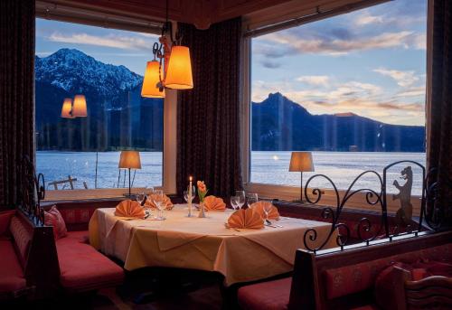 a dining room with a table and a large window at Seehaus am Kochelsee in Kochel
