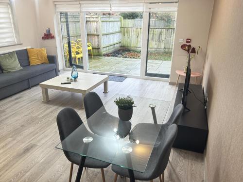 een woonkamer met een glazen tafel en stoelen bij Horizon House, Stunning 2-Bedroom Flat 1, Parking, Netflix, Oxford in Oxford