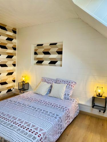 a bedroom with a large bed with two lamps at Les Mariniers in Châteauneuf-sur-Loire