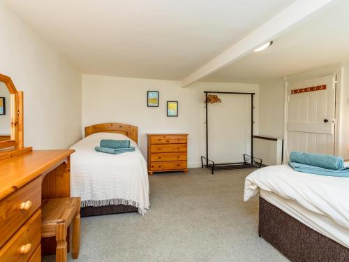 a bedroom with two twin beds and a dresser at Bilton Farm Cottage No1 in Alnmouth