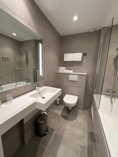 a bathroom with a sink and a toilet and a shower at Brakanes Hotel in Ulvik