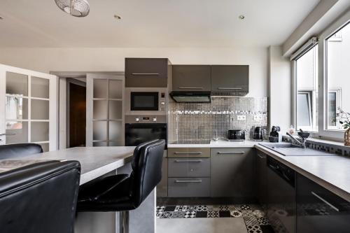 une cuisine avec des appareils en acier inoxydable et une table dans l'établissement Veeve - Lilac Embrace, à Boulogne-Billancourt