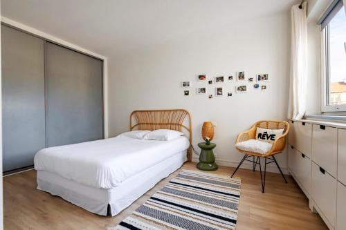 une chambre avec un lit, une chaise et une fenêtre dans l'établissement Veeve - Lilac Embrace, à Boulogne-Billancourt