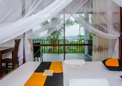 a bedroom with a bed and a balcony at Kurundu Wadiya (Cinnamon Retreat) in Hikkaduwa