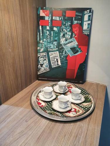 a tray with cups and saucers on a table with a magazine at Casa em condomínio fechado in Uberaba