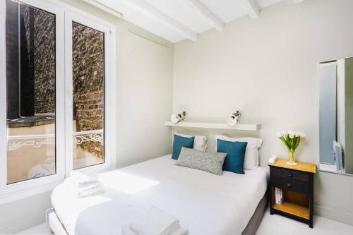une chambre blanche avec un lit et une fenêtre dans l'établissement Special! 500m to Eiffel Tower: Duplex with terrace, à Paris