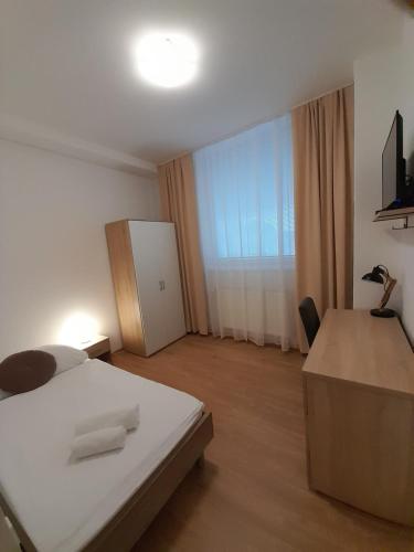 a bedroom with a white bed and a large window at Agro Complex Apartments in Nitra