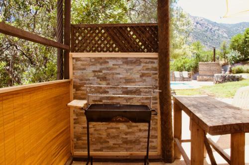a barbecue on the back porch of a house at Loft de montaña Los Guayacanes in San José de Maipo