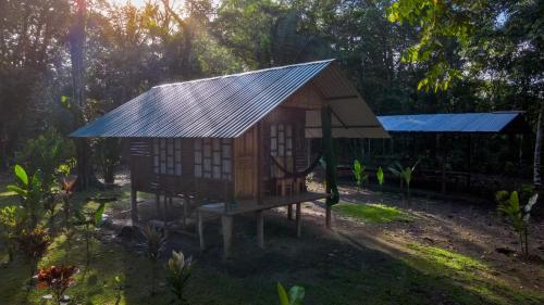 a small house with a tin roof in a yard at Playa Ganadito Ecolodge in Drake