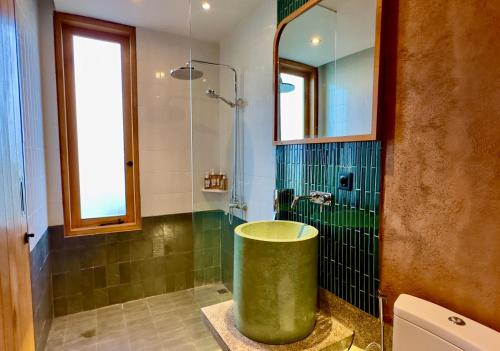 y baño con ducha y bañera verde grande. en New! Gorgeous 3BD Villa close to Canggu, en Tanah Lot