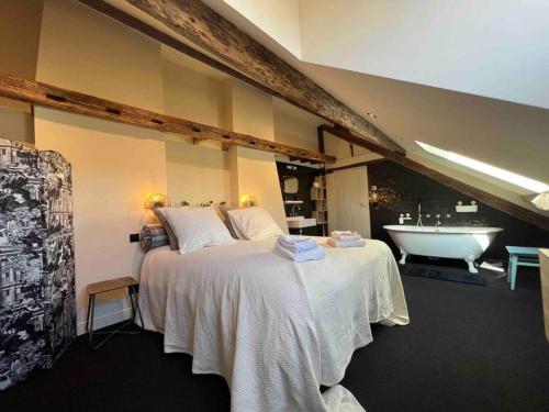 a bedroom with a large bed and a bath tub at Suite Versailles Quartier Saint-Louis 6 personnes in Versailles