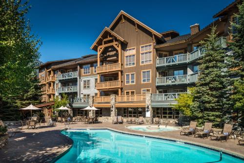 a resort with a swimming pool in front of a building at Legends in Whistler