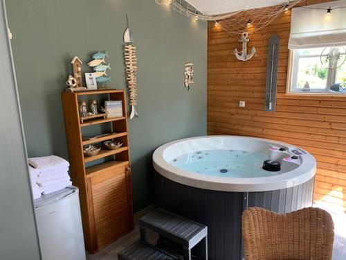 un bagno con una grande vasca in una stanza di B&B Petit Chateau a Biervliet