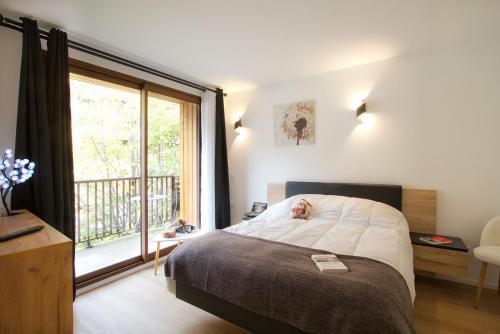 a bedroom with a bed and a large window at Résidence Provençal by Leavetown Vacations in Les Deux Alpes