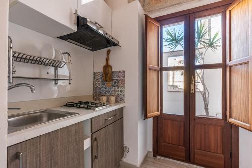 a kitchen with a sink and a window at Carini House Near the Cathedral by Wonderful Italy in Palermo