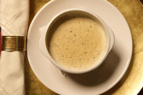 a bowl of soup on a plate on a table at Le Cedrus Hotel in Al Arz