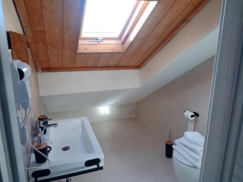 a bathroom with a sink and a skylight at San Rocco Rooms in Palmi