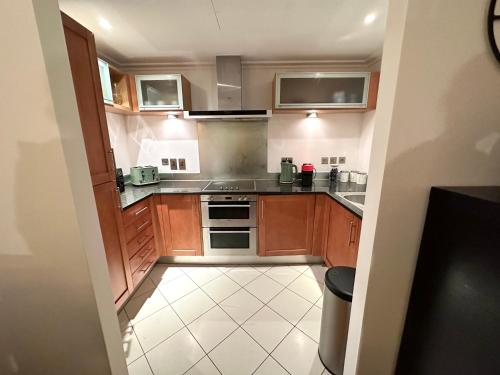 a small kitchen with wooden cabinets and stainless steel appliances at NEW Spacious 2 bedroom Apartment with Balcony in London