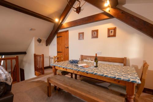a dining room with a table and a bottle of wine at The Coach House, Skelwith Bridge in Grasmere