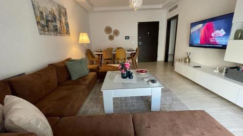 a living room with a brown couch and a table at Schöne, ruhige neuwertige 127qm Ferienwohnung in Sidi Daoud
