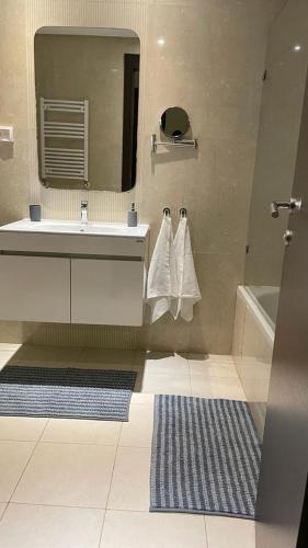 a bathroom with a sink and a tub and a mirror at Schöne, ruhige neuwertige 127qm Ferienwohnung in Sidi Daoud