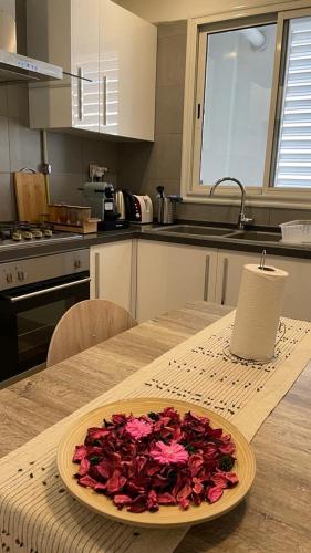 a plate of flowers on a table in a kitchen at Schöne, ruhige neuwertige 127qm Ferienwohnung in Sidi Daoud