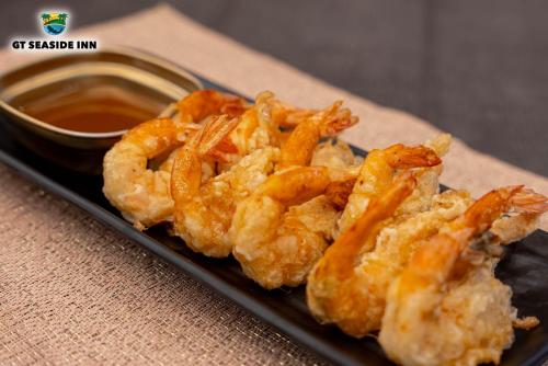 a plate of shrimp with dipping sauce on a table at GT Seaside Inn in Oslob