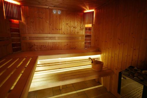 a wooden sauna with a bench and a bucket in it at Harmónia Vendégház Tahitótfalu in Tahitótfalu