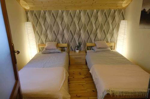 2 camas individuales en una habitación con pared en Harmónia Vendégház Tahitótfalu, en Tahitótfalu