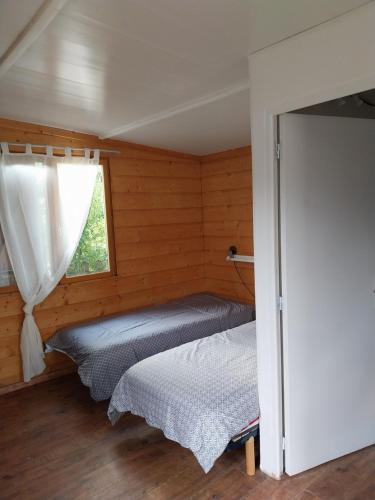 une chambre avec deux lits et une fenêtre dans l'établissement Le petit chalet, à Chanas