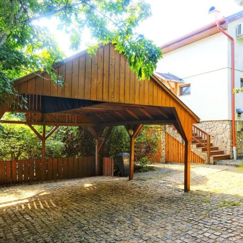 a wooden pavilion in front of a house at Harmónia Vendégház Tahitótfalu in Tahitótfalu