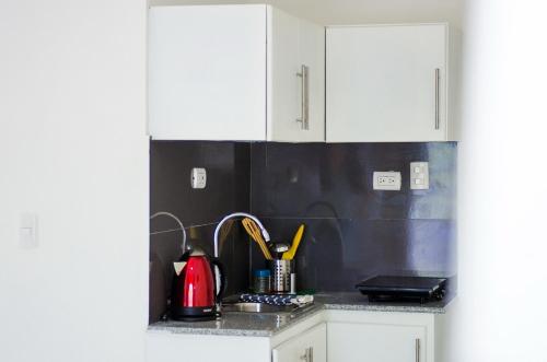 a kitchen with white cabinets and a sink at Art Villa Dominicana in Punta Cana