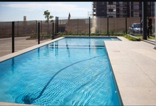 a large blue swimming pool in front of a fence at Nid de Rêve Accommodation in Midrand