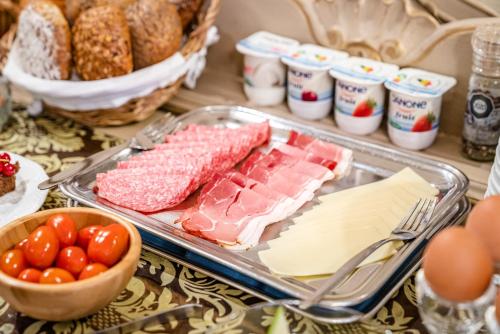 a table with a tray of meats and cheese and bread at Hotel Van Eyck in Bruges