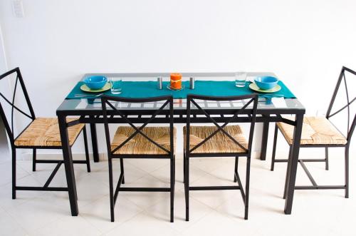 a black dining room table with two chairs and a blue table at Art Villa Dominicana in Punta Cana