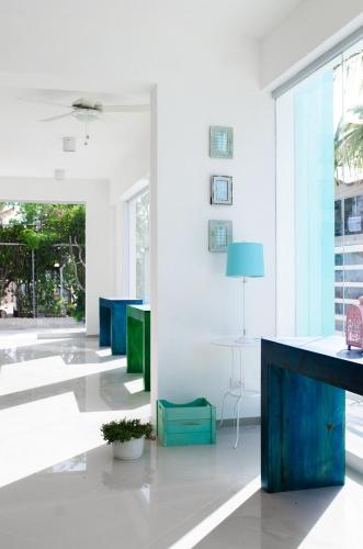 a living room with white walls and blue furniture at Art Villa Dominicana in Punta Cana