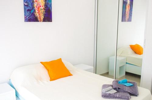 a bedroom with a white bed and a mirror at Art Villa Dominicana in Punta Cana