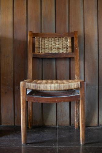 a wooden chair sitting in front of a wall at Frenchman's Cove Resort in Port Antonio