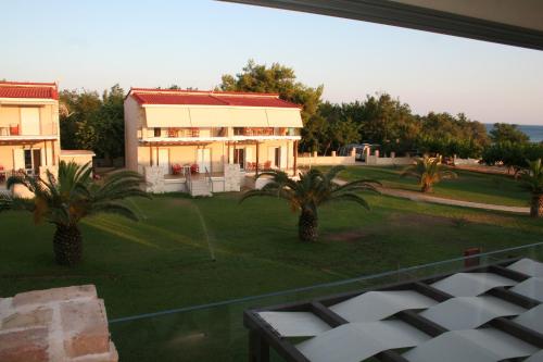 a view of a house with palm trees in the yard at Ionion Beach Apartment Hotel & Spa in Arkoudi