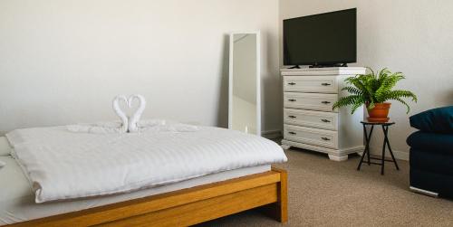 a bedroom with a bed and a dresser with a tv at AeroCafe in Partizánske