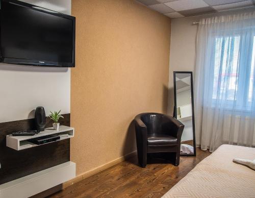 a room with a chair and a television on the wall at AeroCafe in Partizánske