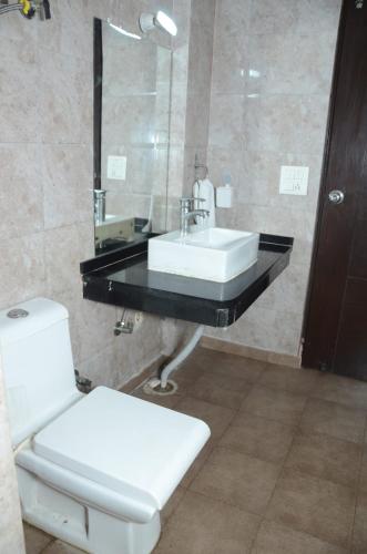 a bathroom with a sink and a toilet at Rumaisa Red in Noida